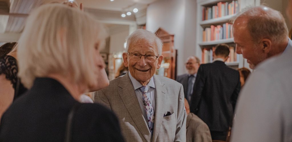 smiling man wearing suit standing beside man