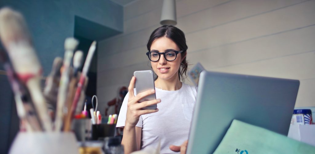 woman in white shirt using smartphone