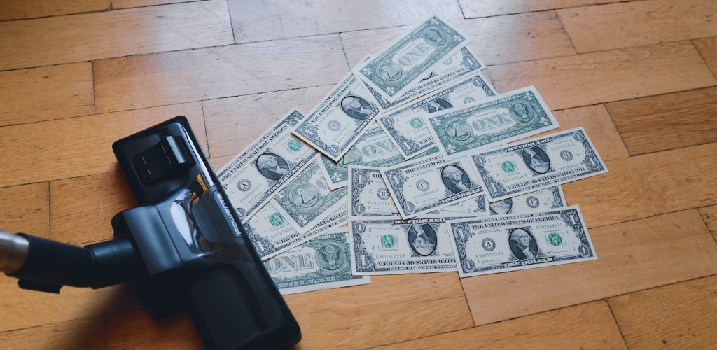 a pile of money sitting on top of a wooden floor