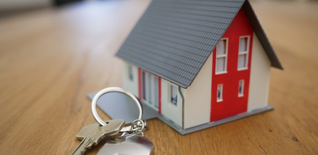 white and red wooden house miniature on brown table